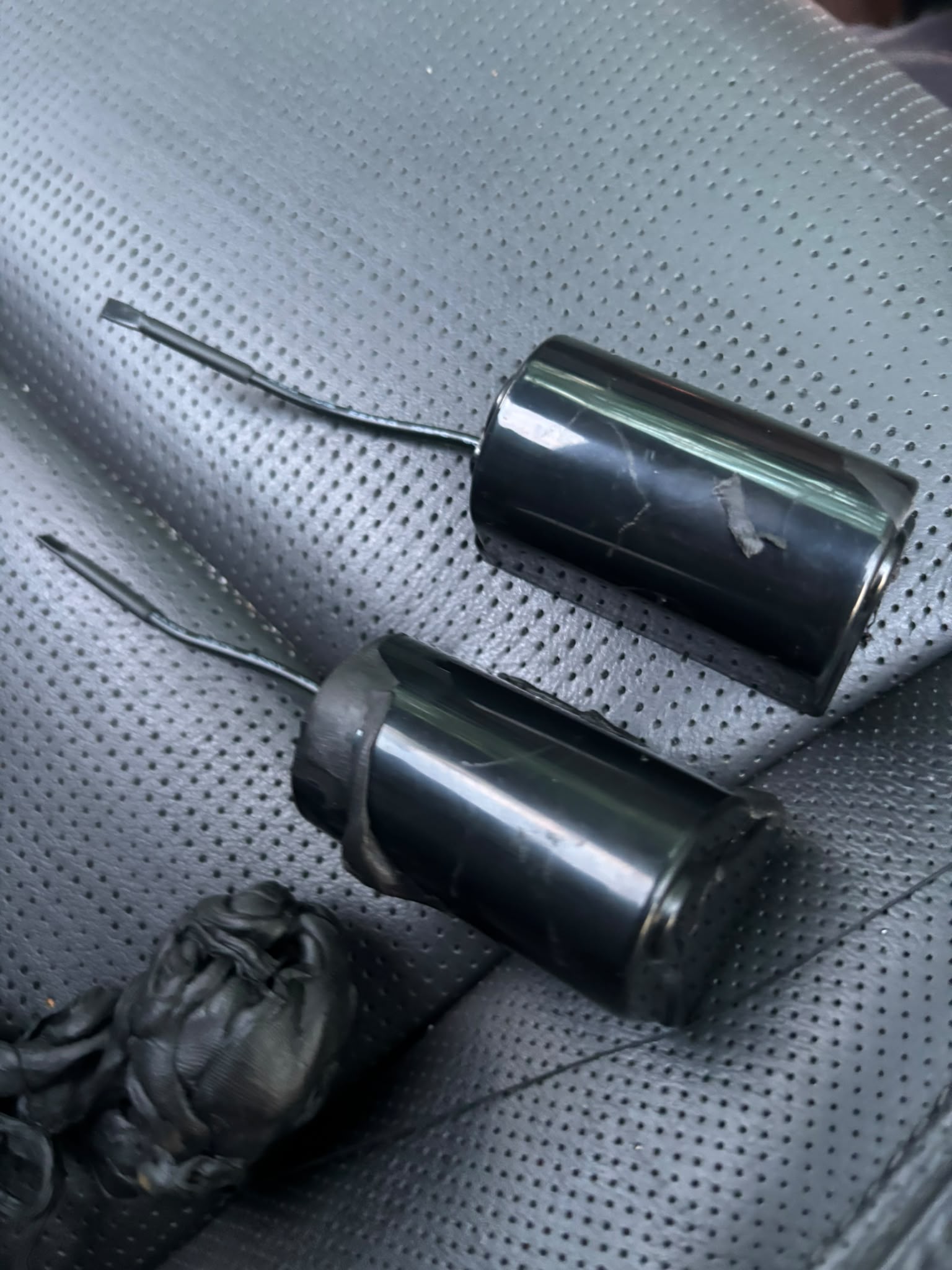 Recovery #2 — two cylindrical tracker units after tape removal, alongside the original tape wad